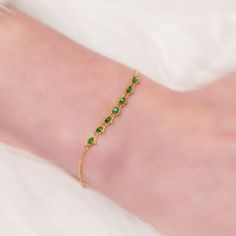 Emerald Textile Station Bracelet on a wrist diagonal view Understated Luxury, Yellow Gold Chain, Green Gemstones, Vibrant Green, Delicate Bracelet, Gold Chain, Gold Chains, Hand Woven, Gemstone Beads