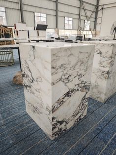 two marble counter tops sitting on top of a blue carpeted floor in an industrial building