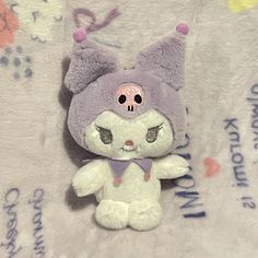 a small stuffed animal is sitting on a blanket with writing around it and eyes closed