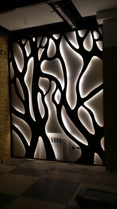 an artisticly designed wall in the middle of a room with black and white walls