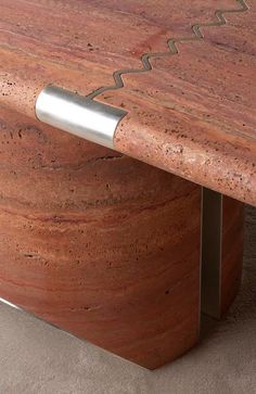 a close up view of a wooden table with metal legs and a red marble top