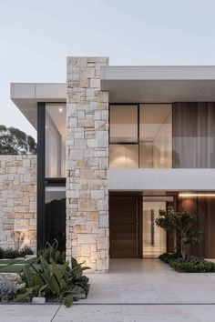 an exterior view of a modern house with stone and wood