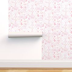 a white wall with pink flowers on it and a roll of paper next to it