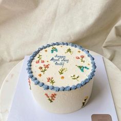 a white cake with blue frosting sitting on top of a plate