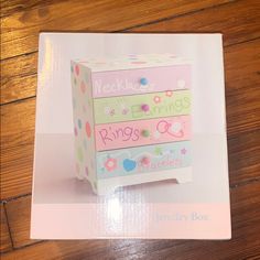 a pink and green box on top of a wooden floor next to a brown table