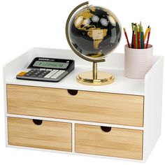 a desk with drawers and a small globe on top of it, next to a calculator