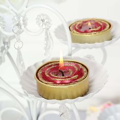 two red candles sitting on top of white plates