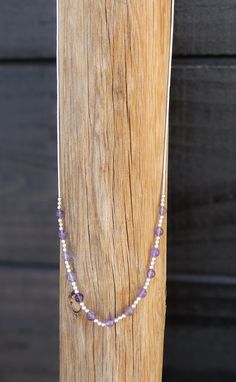 This hand strung necklace is made with Sterling Liquid silver and Amethyst. This is a single strand necklace. There are Liquid silver beads strung and nine small round purple Amethyst beads in between. This is a gorgeous necklace that has a barrel clasp.  16"  Amethyst (3mm) Barrel Clasp 4 Grams Adjustable Sterling Silver Beaded Necklaces, Adjustable Sterling Silver Crystal Necklace With Gemstone Beads, Adjustable Silver Necklaces With Gemstone Beads, Dainty Silver Necklace With Gemstone Beads, Dainty Silver Beaded Adjustable Necklaces, Spiritual Single Strand Sterling Silver Beaded Necklaces, Silver Spiritual Necklace With Tiny Beads, Spiritual Silver Necklace With Tiny Beads, Adjustable Silver Beaded Necklace For Meditation