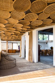 the inside of a building with wicker ceilinging and wooden furniture on it's sides