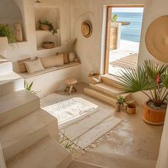 a room that has some plants on the floor in front of it and stairs leading up to an open door