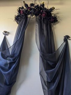 two drapes with flowers on them hanging from the wall