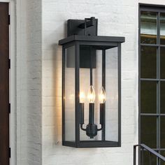 Illuminate your front door or garage with this contemporary candle style exterior wall mounted lantern sconce light. This wall lamp is rated for wet locations. Its well-constructed sturdy frames are made from metal in a powder-coated black finish, plus the 4 clear glass panels with a elongated shape enclosed in a black and sleek/elegant framework, which complements your decor from classic to rustic, ideal for Front Porch, Patio, Garage, Deck etc. Plus, it's compatible with a dimmer switch, so yo Garage Door Lanterns, Exterior Entry Lighting, Black Exterior Lights, Exterior Porch Lights, Lantern Lighting, Exterior Lights, Wall Mount Lantern, Porch Lights, Exterior Light Fixtures