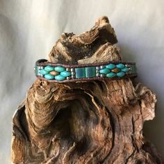 Unique, Southwestern inspired, handmade leather and beaded bracelet. This bracelet, is a single strand using Opaque Yellow Copper Picasso and deep turquoise tone Picasso SuperDuo glass beads, as well Matte Transparent Green Tila beads. They have been accented by Gilded Marble Turquoise colored seed Adjustable Turquoise Leather Bohemian Bracelet, Adjustable Rustic Turquoise Leather Bracelet, Artisan Turquoise Beaded Bracelets Adjustable, Rustic Handmade Turquoise Beaded Bracelets, Adjustable Turquoise Leather Bracelet In Rustic Style, Adjustable Turquoise Beaded Artisan Bracelets, Southwestern Beaded Wrap Bracelet As Gift, Turquoise Beaded Bohemian Wrap Bracelet, Beaded Leather Festival Bracelet