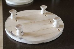 a wooden board with some white spools attached to it on a black table