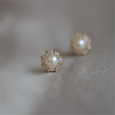 Simple and timeless. Every girl needs a pair of classic pearl studs in their jewelry box! This pair has a modern twist, with a 14K gold or silver halo of alternating CZ stones and shiny beads surrounding a gorgeous faux pearl. DETAILS & SIZE Sold as a pair Finish: 14K gold plate Materials: .925 sterling silver; CZ stones; faux pearl Measurements: 7mm Comes with friction earring backs Shop the Ear Bar to curate your ear stack Small Earrings Gold, Top Earrings, Stud Earrings Women, 14k Gold Plated Jewelry, Silver Pearl Earrings, Simple Pearl, Indian Gowns, Fashion Enthusiast, Jewelry Simple