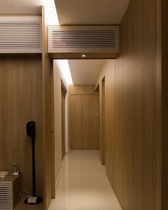 an empty hallway with wood paneling and white tile flooring is seen in this image