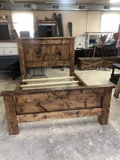 a bed frame made out of wood sitting in a room with other furniture and tools