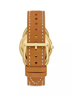 The Tory Burch Miller Goldtone & Leather Analog Watch is the perfect accessory for any fashion-focused Instagram feed. Featuring a sleek goldtone case, leather strap and vibrant cream dial accented by Tory Burch's iconic cursive logo, this watch brings timeless style and luxury to any outfit. As durable as it is designer, it's water resistant and carries the esteemed Tory Burch brand's quality craftsmanship and 2-year warranty. Capture every Instagrammable moment in chic simplicity with the Mill Luxury Gold Watch With Leather Strap, Luxury Gold Watch Accessories With Leather Strap, Classic Watches With Gold-tone Hardware And Rectangular Dial, Gold Leather Business Watch, Gold Leather Watches With Diamond Hour Markers, Gold Leather Watch For Business, Modern Gold Watch With Leather Strap, Gold Watches With Leather Strap For Business, Yellow Gold Leather Watch With Round Dial