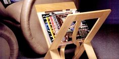 a magazine rack sitting on top of a chair next to a leather seat with magazines in it