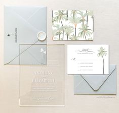 wedding stationery with palm trees on the back and inside, including an envelope and ring