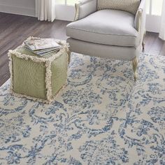 a living room with a chair, ottoman and rug