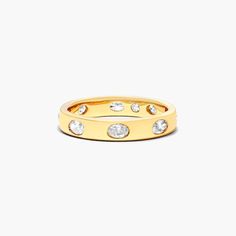 a yellow gold ring with three diamonds on the inside and outside, set against a white background