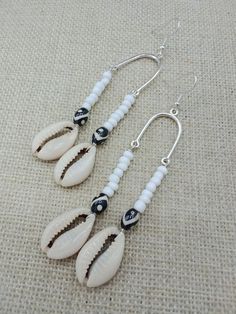 The earrings are handmade beaded and light weight. The earrings are beaded with cowrie shells, glass and ethnic beads. The earrings are 3.5 inches long. If you have any questions please feel free to contact us at anytime. All shipping options are available. All items will be shipped out Monday through Friday. Receipts will be emailed out for immediate access. All items will be shipped out carefully and every shipment can be made with extra insurance upon request. All other concerns and details can be found in our policy section. Our goal is for your 100% satisfaction. If you would like to make a large order please contact us for a coupon code. Our products are not intended for babies or children as we use small pieces, wires and beads. These can be dangerous to them when unsupervised. Gift Handmade White Heishi Beads Earrings, Bohemian Dangle Beaded Earrings For Vacation, Bohemian Beaded Earrings For Vacation, Handmade Beaded Earrings For Beach, Bohemian Beaded Dangling Earrings For Vacation, Handmade White Beaded Earrings For Vacation, Bohemian White Earrings For Beach, Adjustable White Beaded Earrings With Silver Beads, White Beaded Earrings For Summer Beach