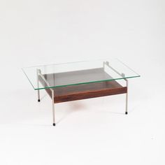 a glass and wood coffee table with metal legs