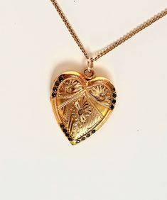 This is a rare beautiful vintage antique 14K gold filled heart locket with scroll design of Fleur-de-lis, floral etched and surrounded 16 stones around the edge. The locket has amazing engraved flowers. Inside the locket has a frame for picture. The backside is plain. This locket is charming piece of jewelry that is sure to steal your heart. A condition is excellent, with no damages or repairs. It hangs from 18" chain necklace that is marked 14K gold filled. Large locket measures 1 1/8" X 1" . Cheap Vintage Gold Locket Necklace, Valentine's Day Yellow Gold Jewelry With Intricate Design, Antique Heart-shaped Yellow Gold Jewelry, Collectible Gold Jewelry With Heart Charm, Victorian Locket Jewelry For Valentine's Day, Victorian Jewelry With Heart Charm For Anniversary, Victorian Locket For Valentine's Day, Victorian Yellow Gold Jewelry For Valentine's Day, Heirloom Engraved Locket Necklace For Valentine's Day