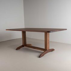 a wooden table sitting on top of a white floor