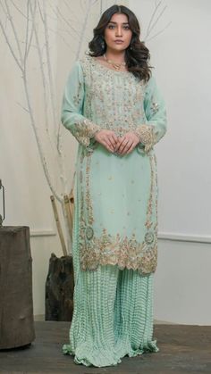 Introducing our exquisite Sea Green Organza Raw Silk Sharara Outfit, a perfect blend of elegance and tradition tailored for your special occasions. This stunning ensemble is meticulously crafted, making it an ideal choice for weddings, Eid celebrations, parties, and other festive events. The dress features a captivating sea green color, symbolizing freshness and sophistication. The use of premium quality organza and raw silk adds a touch of luxury, ensuring a graceful drape and a comfortable fit.The dupatta on organza adds a beautiful finishing touch. Naqshkaar is a luxury fashion house based in Faisalabad, Pakistan established in 2019. The brand reflects its art of aesthetics by incorporating new cuts into the fusion of old and new traditions. Being true to its name, Naqshkaar gives great Sea Green Pakistani Suit, Semi-stitched Sharara For Eid Ceremony, Semi-stitched Sets For Eid Ceremony, Elegant Dabka Reception Gown, Elegant Wedding Sharara With Zari Work, Elegant Green Salwar Kameez For Reception, Green Elegant Salwar Kameez For Reception, Traditional Drape Sharara For Eid Ceremony, Eid Ceremony Traditional Drape Sharara