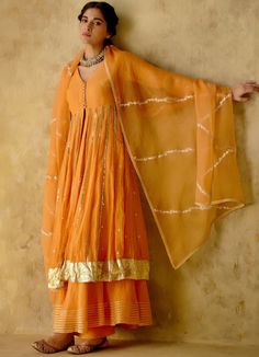 Features a tangerine front open silk anarkali embellished with zari & patra work, finished with gota lace & button detailing on the front. Completed with a matching sharara with lace detailing and an embellished dupatta. Composition : Anarkali & Sharara: Chanderi Silk Lined with Mul Cotton, Dupatta: Organza Care: Dry Clean Only and Vacuum Storage All products can be customised for sleeves, length of blouse and neck design Delivery : 3-4 weeks as the product is hand crafted. Check Size Guide or choose MySize for free customisation (All Sizes above XL can be made at 15% additional cost) For more information and sizes please contact fabiliciousfashion@gmail.com or visit our Copenhagen studio. Orange Anarkali, Silk Anarkali, Vacuum Storage, Cotton Dupatta, Designer Dresses Casual, Lace Button, Sharara Set, Cotton Set, Lace Embroidery