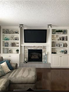 a living room filled with furniture and a flat screen tv mounted on the wall above a fireplace