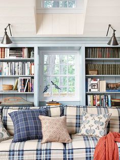 a couch with pillows and bookshelves in front of it on the instagram page