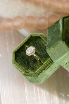 an engagement ring in a green velvet box