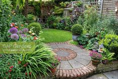 a garden with lots of plants and flowers in the center, surrounded by greenery