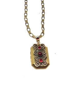 An antique gold finished costume locket and chain with red stones signed "Hobe" on the back. The chain features alternating oval and flower shaped links and is  47 cm long. The locket measures 3 cm by 2 cm, and is decorated with filigree and three red stones. The bail has a red stone too. The locket hinges open and one frame is still there. It is in excellent condition. Antique Gold Brass Locket Necklace With Filigree, Red Locket Necklace For Formal Occasions, Red Victorian Engraved Necklace, Victorian Red Engraved Necklace, Red Medallion Locket Necklace, Red Vintage Filigree Necklace, Red Antique Engraved Necklace, Antique Red Engraved Necklace, Antique Red Locket Necklace