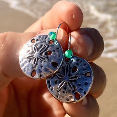 gorgeous and elegant silver sand dollar earrings perfect gift for beach lovers! * silver sand dollar * hypoallergenic stainless steel silver french hook ear wires  * transparent teal glass accent beads * add a matching bracelet! Handmade by me with Aloha in Hawaii they arrive ready for gifting with my LIVE ALOHA card, inside a delicate deep ocean blue organza bag. *to ensure safety in transit, earrings are now shipped inside a cute, reusable acrylic jar along with my Live Aloha card and organza bag* SEE ALL MY EARRINGS HERE: https://www.etsy.com/shop/LOphoto808?ref=br_feed_17&br_feed_tlp=art§ion_id=17783609 shipping additional items is FREE!! please contact me here: https://www.etsy.com/conversations/new?with_id=30970463 if you need assistance with ordering or have any questions. PLEASE VI Silver Dangle Earrings For Vacation, Silver Earrings For Summer Vacation, Handmade Silver Jewelry For Beach Season, Ocean-inspired Silver Jewelry For The Beach, Silver Ocean-inspired Jewelry For The Beach, Silver Ocean-inspired Jewelry For Beach, Beachy Silver Vacation Jewelry, Ocean-inspired Silver Beach Jewelry, Nickel Free Sterling Silver Jewelry For Beach