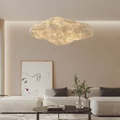 a living room filled with furniture and a large light fixture hanging from it's ceiling