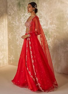 Unveil your inner elegance with the exquisite Red Embroidered Silk Organza Lehenga Set, a perfect blend of tradition and modernity. Crafted from pure silk organza, this ensemble features a red lehenga that exudes opulence through its all-over handwork motifs, adding a touch of luxury to every twirl. Paired with a delicately embroidered blouse, meticulously crafted with intricate aari handwork that showcases timeless artistry, the look is completed with a dupatta adorned with a heavily hand-embroidered border and motifs, elevating the ensemble to a new level of elegance. Perfect for a bride or bride-to-be on your special day, this outfit promises to make you the center of attention with its vibrant hue and breathtaking design. Composition : Dupatta & Lehenga - Pure Silk Organza, Blouse - Me Red Sharara With Sheer Dupatta In Chanderi, Red Raw Silk Traditional Wear With Sheer Dupatta, Red Chanderi Dress With Sheer Dupatta, Red Tissue Silk Traditional Wear With Dupatta, Red Organza Floor-length Saree, Floor-length Red Organza Saree, Elegant Red Anarkali Set With Cutdana, Festive Organza Lehenga For Reception, Diwali Reception Organza Sharara