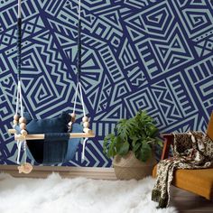 a living room with blue and white wallpaper, wooden swing chair and potted plant