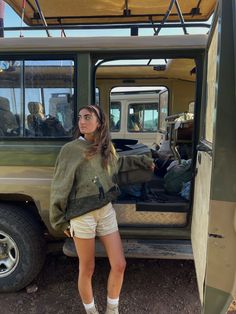 a woman standing in front of a vehicle