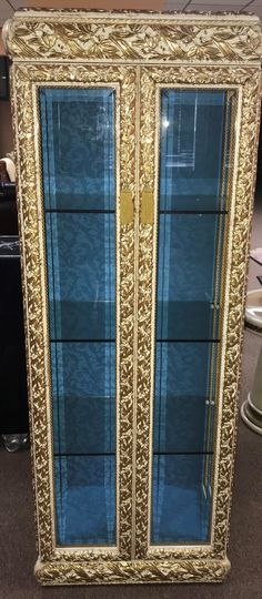 an ornate gold and blue display cabinet with glass doors