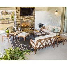 a living room with furniture and a fire place in front of a brick wall that has a screen on it