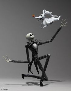 a skeleton is playing with an orange ball in front of another skeleton that has it's legs spread out