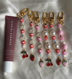 several charms and a tube of lip balm sitting on a bed next to each other