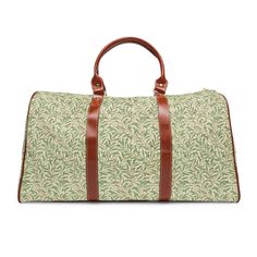 This William Morris travel bag is a perfect weekend bag for a quick getaway or overnight duffle. This luxurious bag is both stylish and functional. It is waterproof, spacious, easy to throw over your shoulder, and gorgeous. This vintage Morris design is of entwined willow leaves. It has been recolored and scaled to make it the ultimate traveler's luggage. If you appreciate maximalism, beautiful colors, sweeping leaves, and vibrant vintage floral patterns then this is the travel bag of your dream Rectangular Duffle Bag With Leather Trim For Weekend Trips, Weekender Satchel Bag With Luggage Sleeve For Overnight Trips, Casual Rectangular Luggage With Leather Handles, Green Weekender Bag With Leather Handles For Travel, Rectangular Duffle Bag With Leather Trim For Overnight Trips, Large Capacity Coated Canvas Bag For Overnight Trips, Leather Trim Rectangular Duffle Bag For Overnight Trips, Casual Travel Bag With Leather Trim For Overnight Trips, Casual Travel Bag With Leather Handles For Overnight Trips