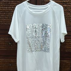 White Fancy Embellished T. Never Worn No Tags. A Bit Big For Me. Size L Silver Sequents In A Square Start Heavy And Go To Lighter Spread Out Pattern. So Cute! Casual Rhinestone T-shirt For Summer, White Crew Neck T-shirt For Party, White Crew Neck Top For Party, White Rhinestone Party Tops, White Embellished Crew Neck T-shirt, Embellished Graphic Tee With Crew Neck, Casual Summer T-shirt With Rhinestones, Trendy White Tops With Rhinestones, White Embellished Crew Neck Top