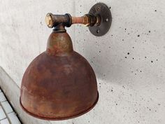 an old light hanging from the side of a wall