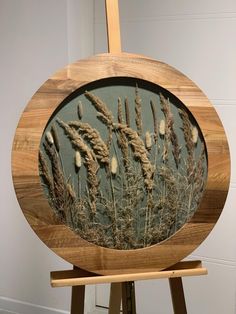 a wooden easel with an image of dried grass in the center and on it's side